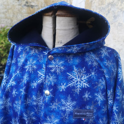 Cape adulte FLOCONS DE NEIGE en softshell avec capuche et fermeture pressionnée devant.