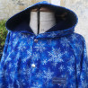Cape adulte FLOCONS DE NEIGE en softshell avec capuche et fermeture pressionnée devant.
